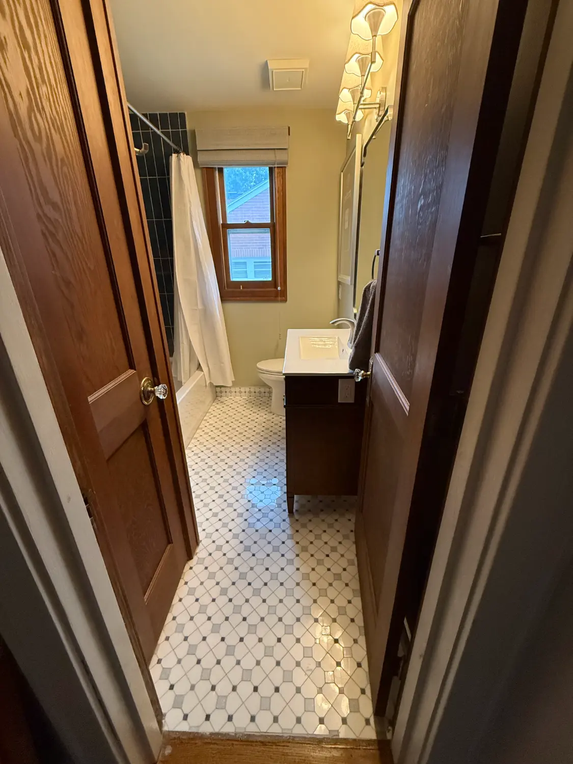 Finished bathroom — octagon and dot mosaic tile floor, new vanity, and glass-enclosed shower