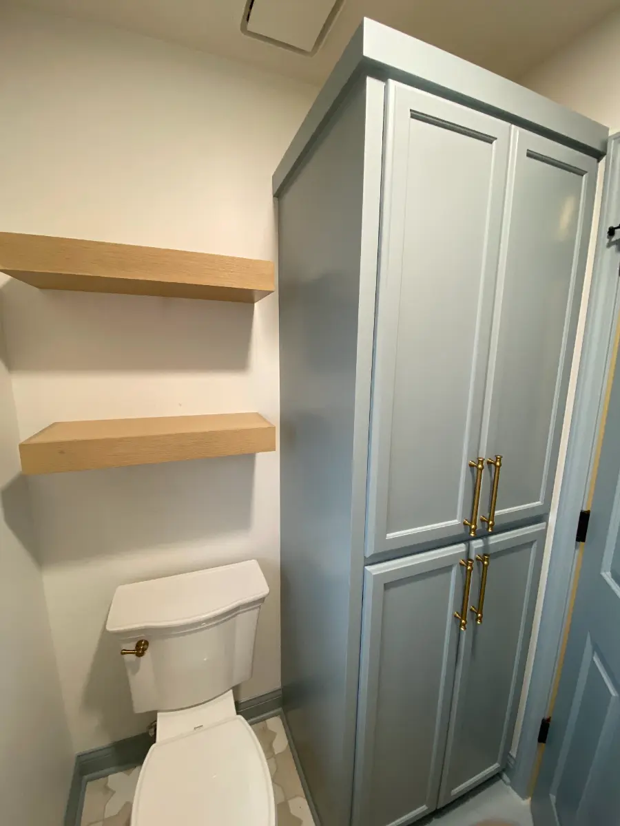 bathroom remodel with custom linen cabinet and floating shelves, after