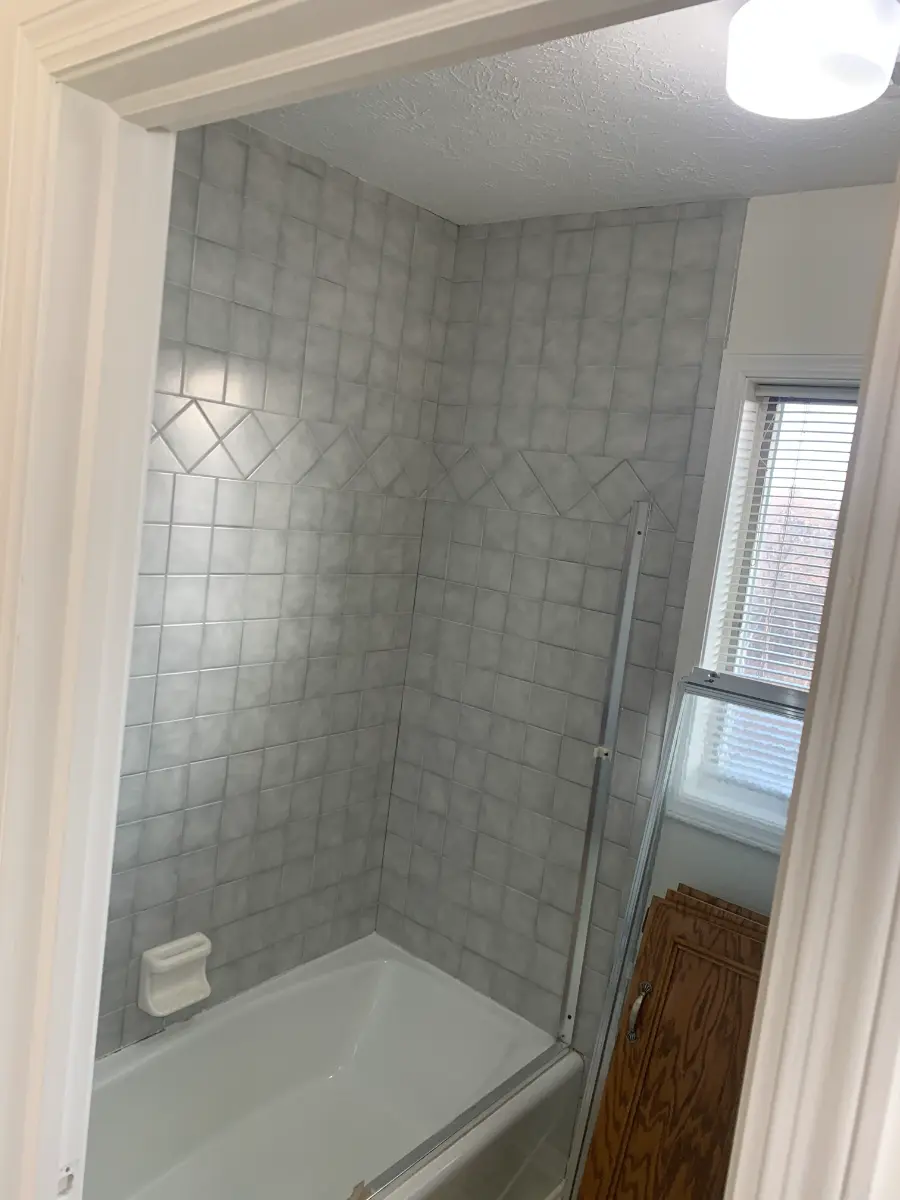 bathroom remodel with wood vanity and patterned tile floor, before