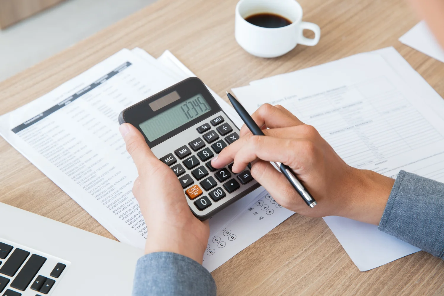Notebook with project notes and a calculator beside a blueprint