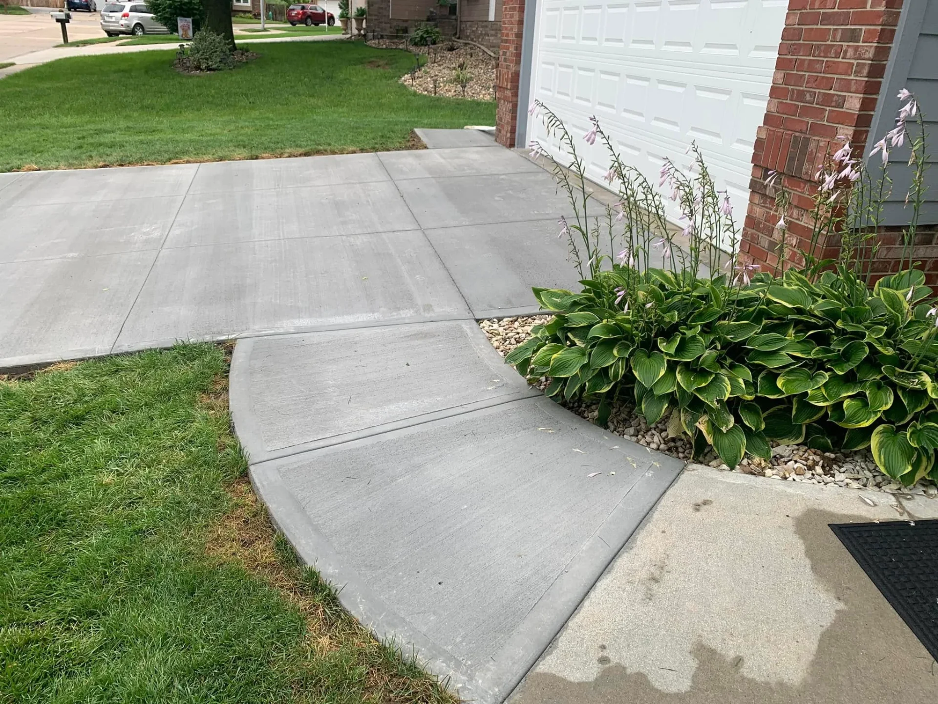 Freshly finished concrete driveway in front of a residential home